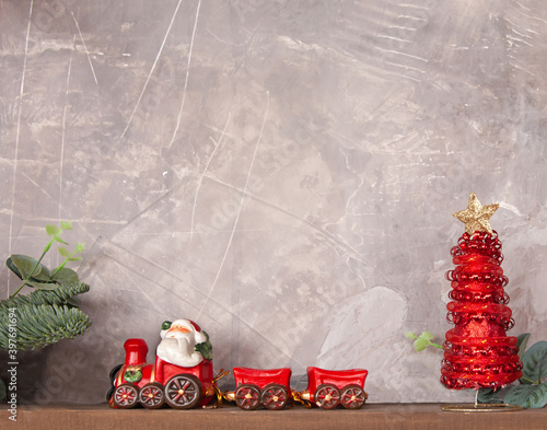 Red Christmas toy train with red Christmas tree and a gray copy space. Decorative concept of the Christmas holiday.
