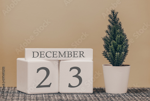 Desk calendar for use in different ideas. Winter month - December and the number on the cubes 23. Calendar of holidays on a beige solid background.