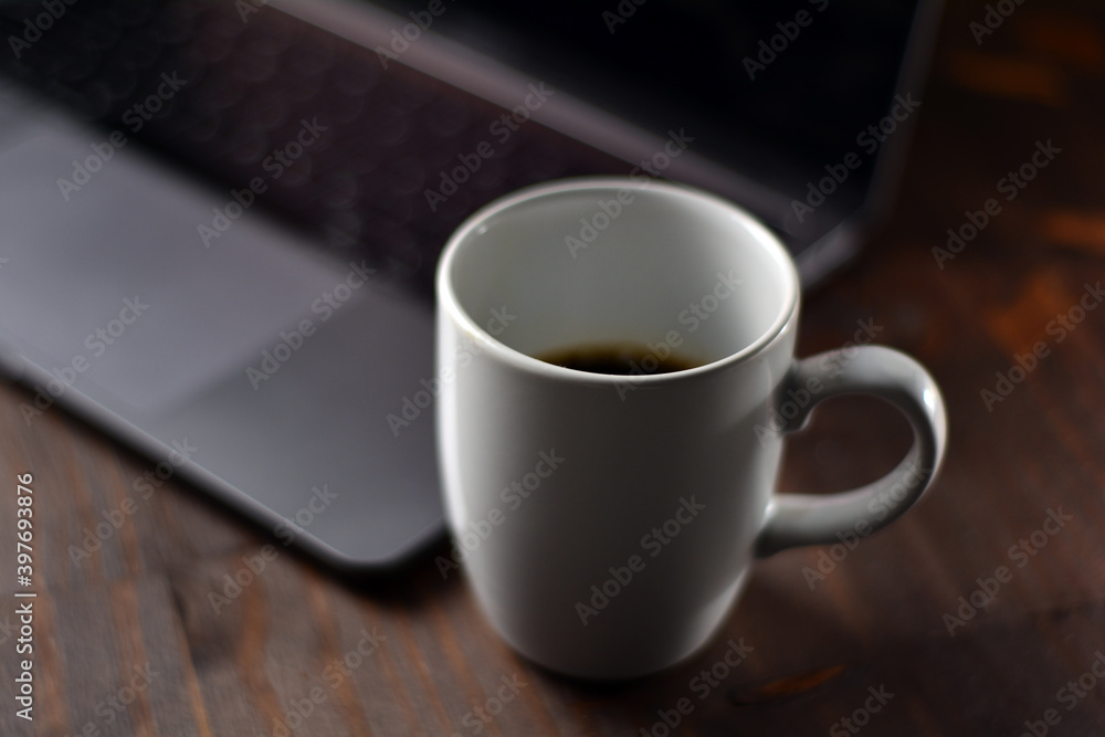 Cup of coffee and notebook on a wooden office table Cup of coffee and notebook on a wooden office table