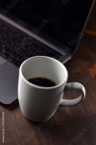 Cup of coffee and notebook on a wooden office table