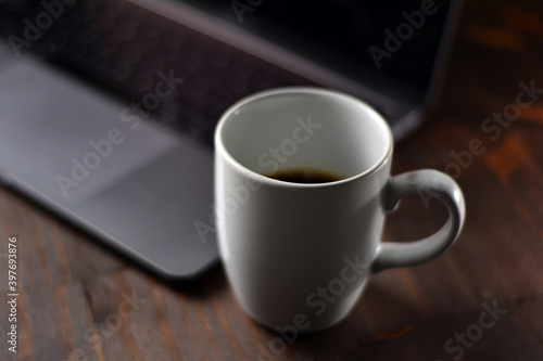 Cup of coffee and notebook on a wooden office table