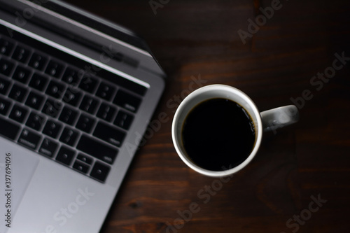 Cup of coffee and notebook on a wooden office table