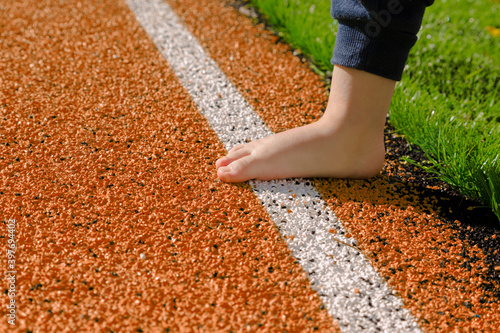 Child's barefoot on athletic track.