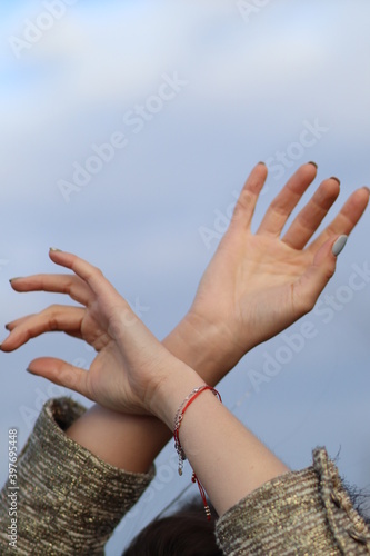 Female hands on the background of clouds