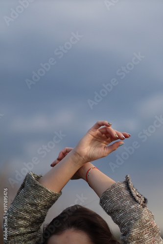 Female hands on the background of clouds