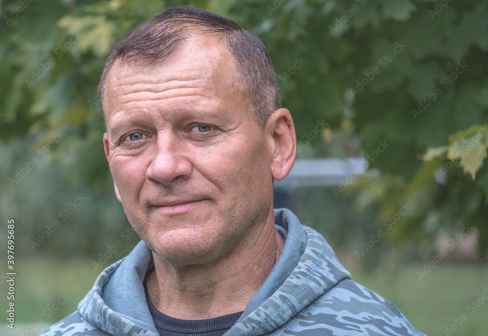 portrait of handsome attractive middle aged man looking with smile, against background of autumn park portrait of handsome attractive middle aged man looking with smile, against background of autumn park