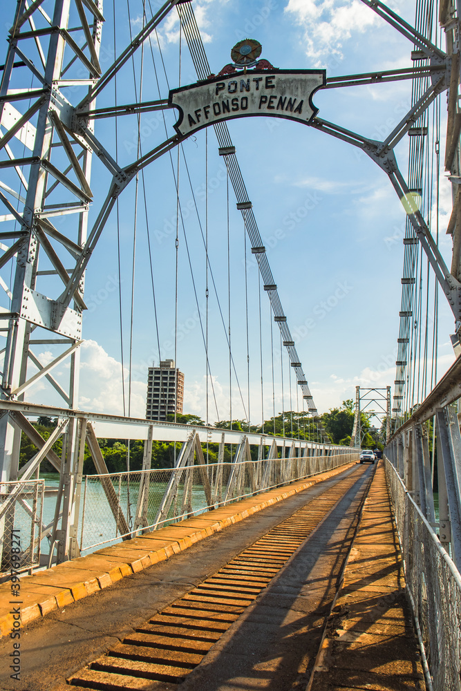 Obraz premium Affonso Pena steel bridge spanning the Paranaíba River, connecting Araporã, Minas Gerais, and Itumbiara, Goiás, Brazil. A stunning engineering structure in a scenic rural landscape