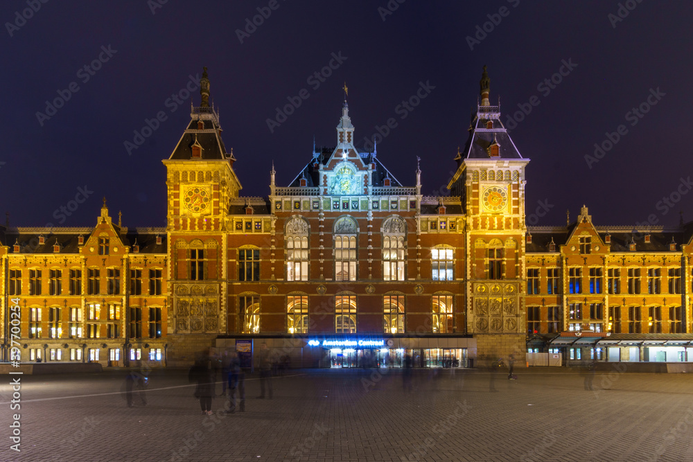 Central station of amsterdam at night with blured moving people