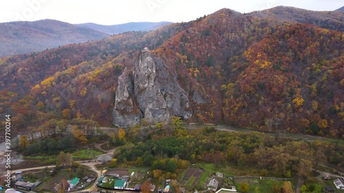 View from above. 4K. Dersu Uzala rock in the village of Kavalerovo, seaside region. Panoramic shooting of a picturesque rock, standing next to a Russian village. photo