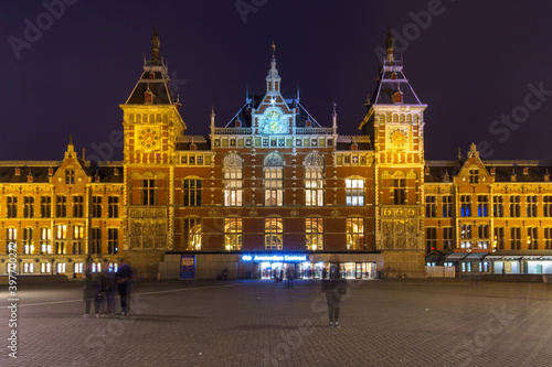 Central station of amsterdam at night with blured moving people