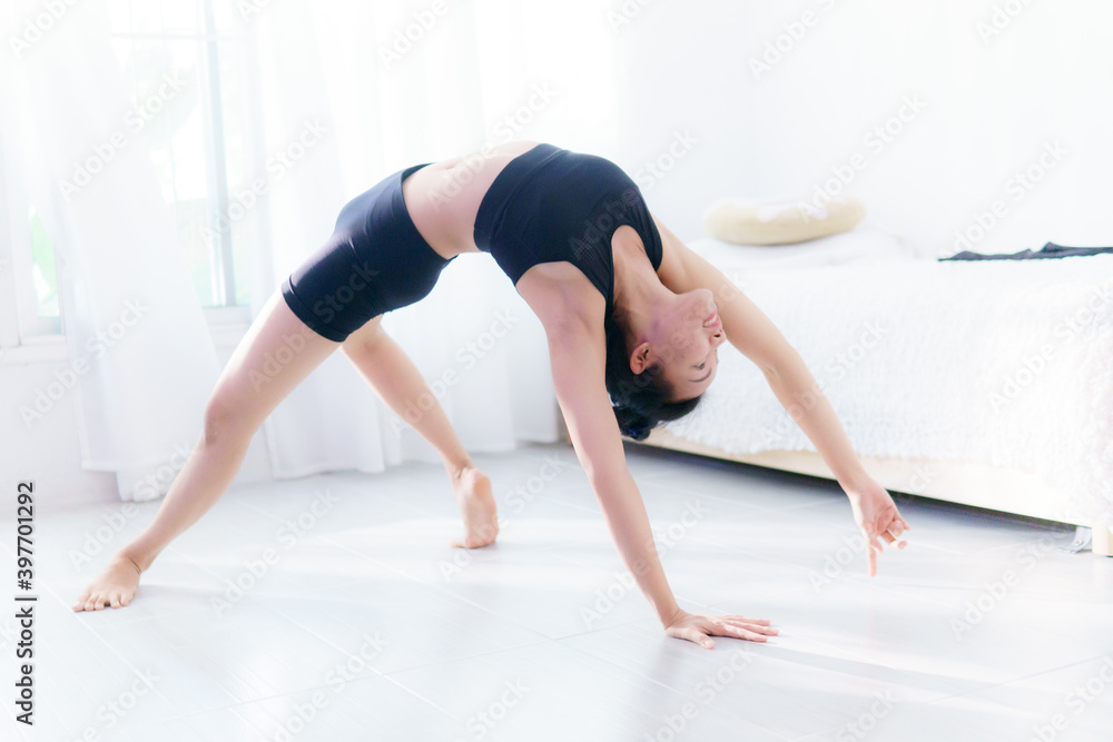 Young Asian woman practice yoga in bedroom in the morning