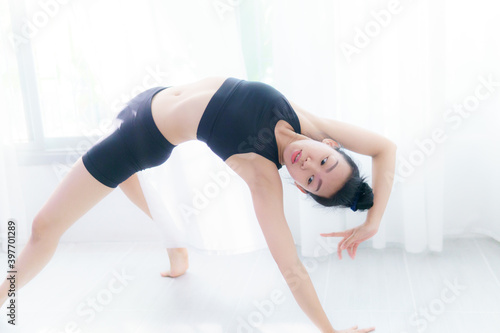 Young Asian woman practice yoga in bedroom in the morning