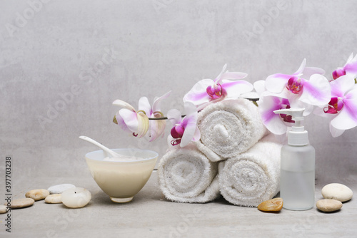 branch pink,white orchid flower with rolled towel and white candle,stones on gray background