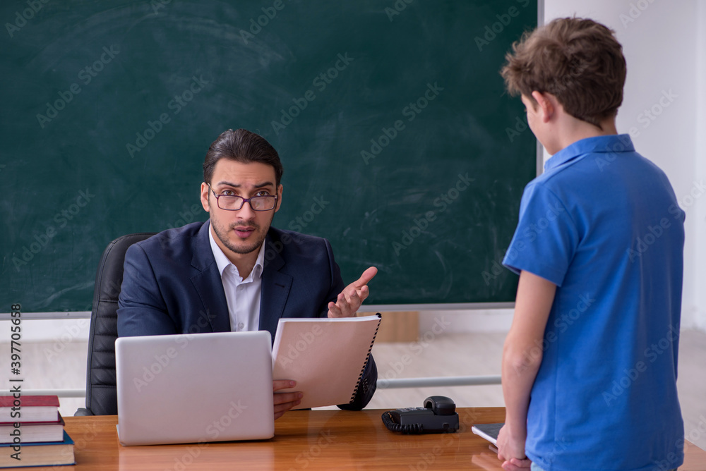 Young male teacher and schoolboy in the classroom Young male teacher and schoolboy in the classroom