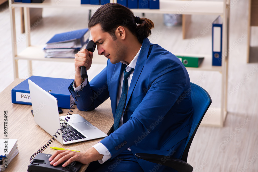 Young handsome employee sitting in the office Young handsome employee sitting in the office