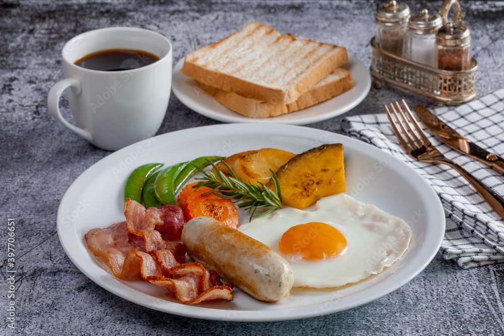 Delicious breakfast bacon, sausage, fried eggs, bread, coffee