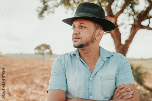 latin american farmer with arms crossed looking to the left