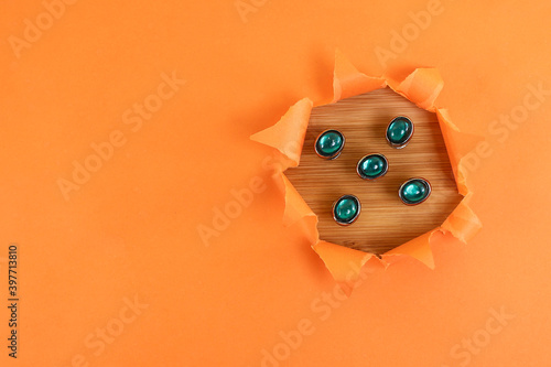 View from above of Malay costume buttons isolated on the wooden and orange background with torn paper effect  photo