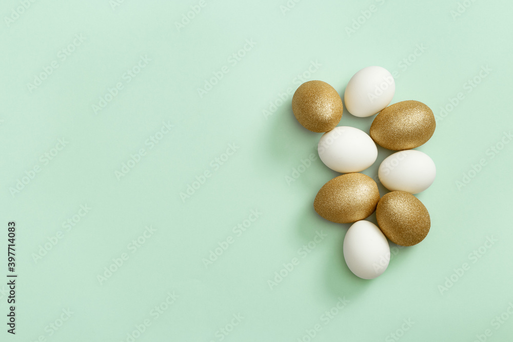 Painted Easter eggs white and gold colored on light green paper. Minimal easter concept. Top view spring holiday background Painted Easter eggs white and gold colored on light green paper. Minimal easter concept. Top view spring holiday background