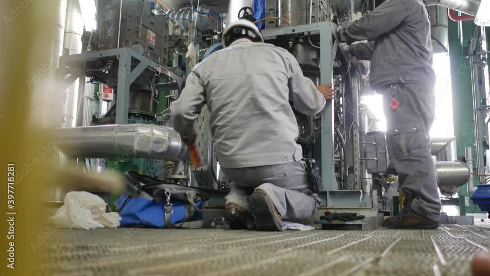 An electrician is disconnecting the wires from the electric motor in preparation for the maintenance of the industrial machinery. An electrician is disconnecting the wires from the electric motor in preparation for the maintenance of the industrial machinery.