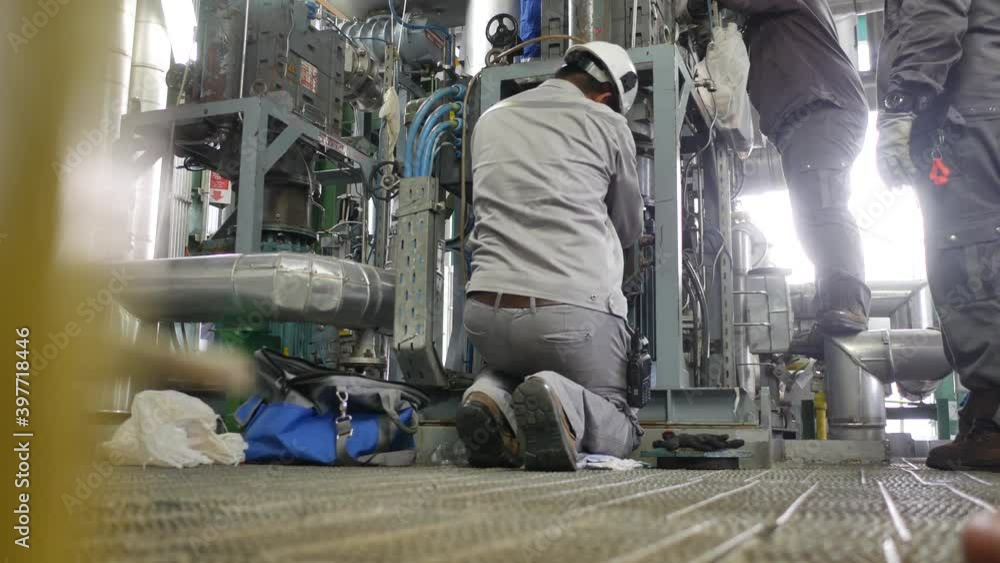 An electrician is disconnecting the wires from the electric motor in preparation for the maintenance of the industrial machinery. An electrician is disconnecting the wires from the electric motor in preparation for the maintenance of the industrial machinery.