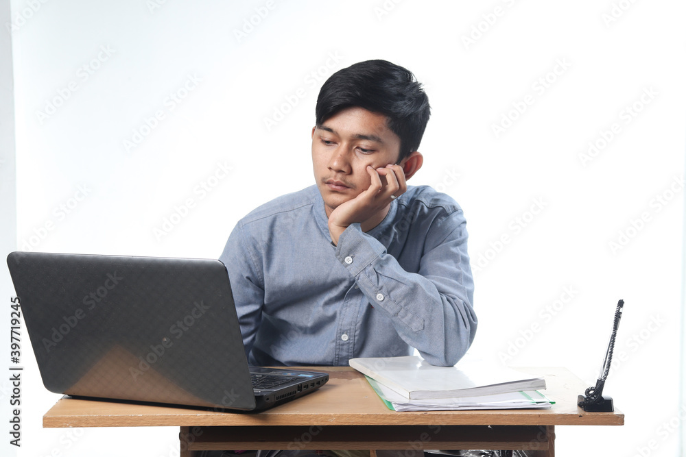 Portrait of Asian men casually working on computer reports and books. office employee bustling concept with isolated white background Portrait of Asian men casually working on computer reports and books. office employee bustling concept with isolated white background
