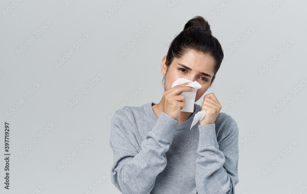 Woman in sweater holding napkin near face with runny nose health problems cropped view Woman in sweater holding napkin near face with runny nose health problems cropped view