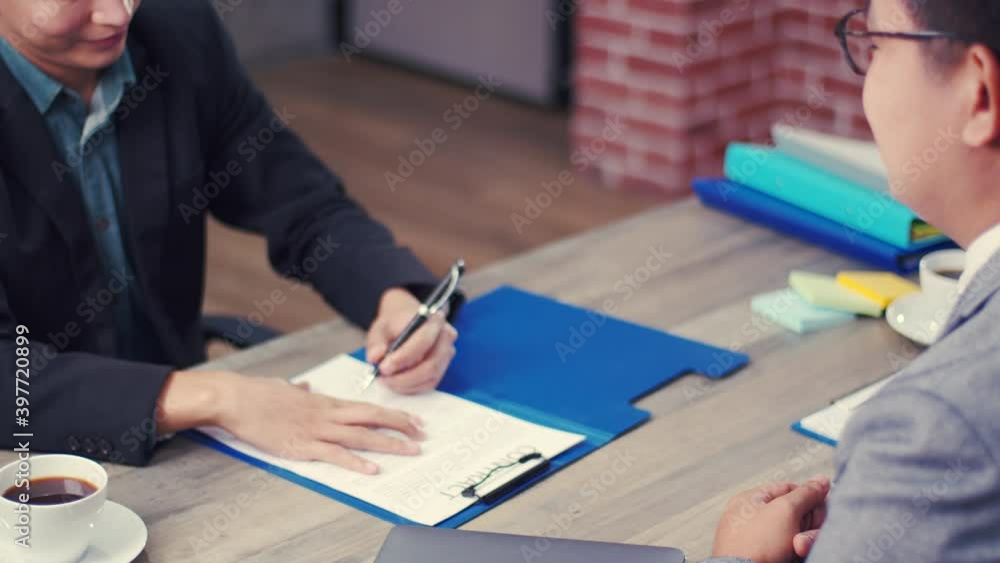 Job interview: Confident executive asking candidate question new employee and sign contract and shaking hands successful corporate partnership deal at the office. Job interview: Confident executive asking candidate question new employee and sign contract and shaking hands successful corporate partnership deal at the office.