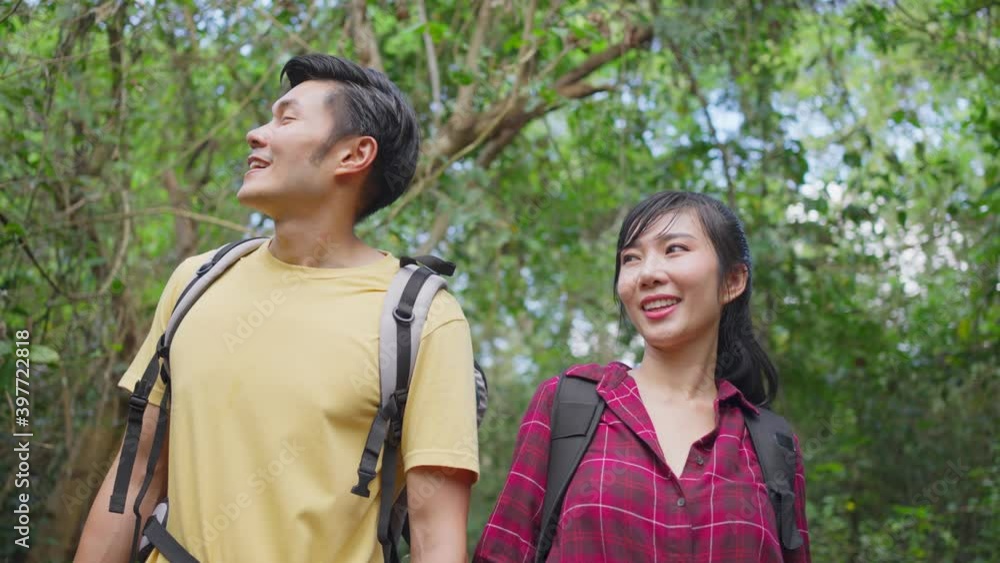 Asian young backpacker couple travel through a forest in the summer. Asian young backpacker couple travel through a forest in the summer.