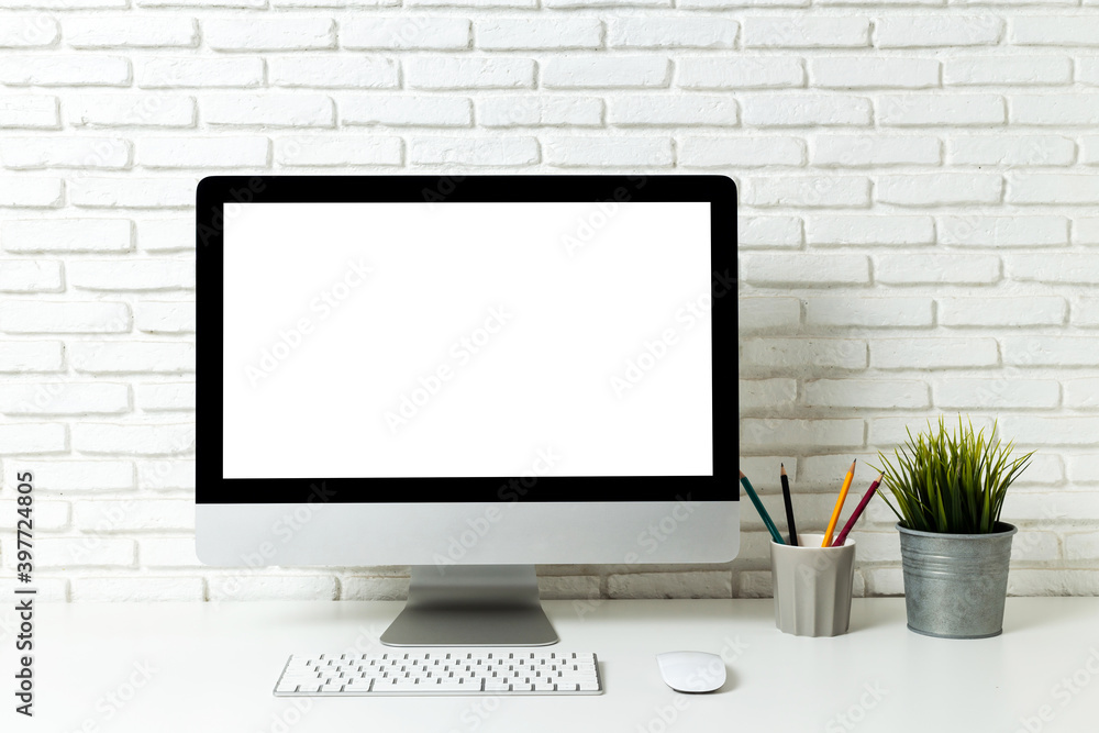 Fototapeta premium Mockup blank screen computer on a wooden desk. desktop empty white screen, with workspace and office supplies on table