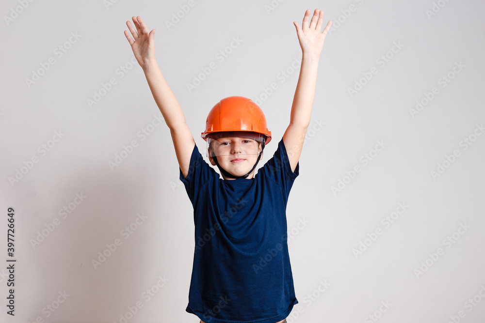 eight-year-old boy in orange helmet working on white background eight-year-old boy in orange helmet working on white background