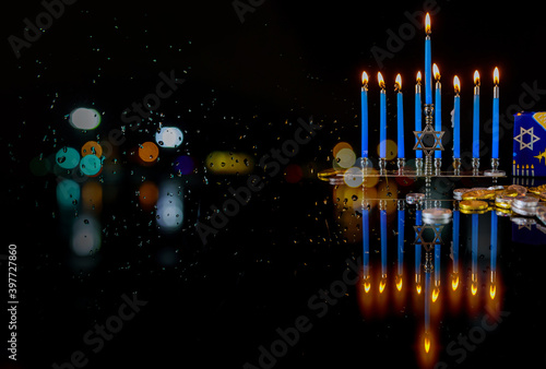 Burning candles with menorah for Hanukkah on defocus lights background. Jewish holiday. photo