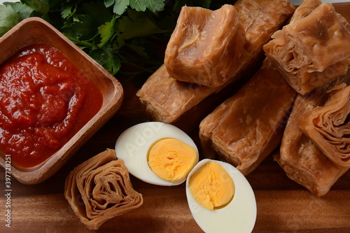 Jachnun or Jahnun, Yemenite Jewish pastry, served with fresh grated tomato and boiled egg and Zhug,  originating from the Adeni Jews, and traditionally served on Shabbat morning in Israel. photo