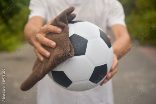 Hand holding Wiping cloth cleaning football © Suriyo