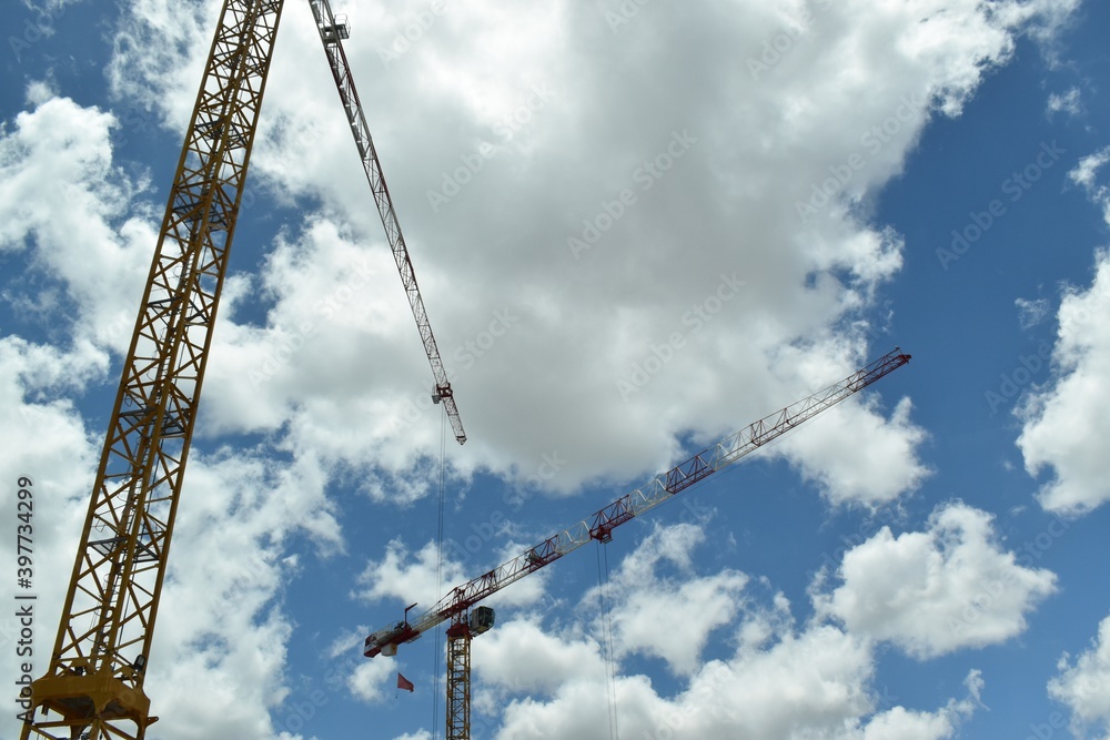 Construction cranes with cloudy sky in background. Construction cranes with cloudy sky in background.