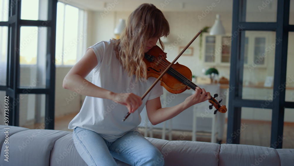 Teenage girl playing violin. Violinist playing chords on musical