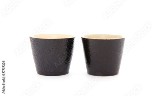 Two black coarse porcelain tea cups on white background