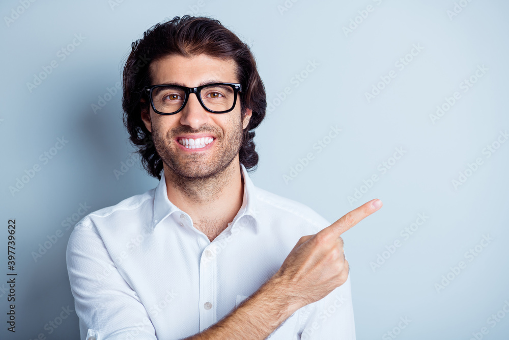 Photo portrait of smiling man pointing finger at blank space isolated on clear white colored background Photo portrait of smiling man pointing finger at blank space isolated on clear white colored background