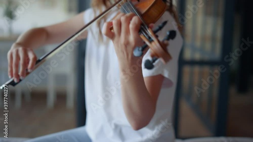 Girl performing composition on violin. Musician creating music on instrument photo