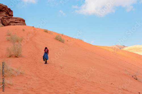 girl wearily climbs up the sand dunes, nature of Jordan
