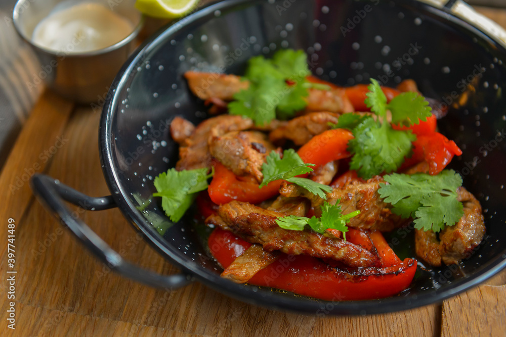 Vegetables and meat in wok pan served with lavash bread and different kinds of sauce. Close up. Vegetables and meat in wok pan served with lavash bread and different kinds of sauce. Close up.