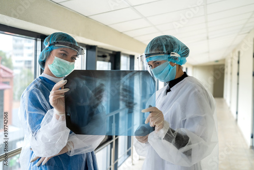 Two young doctors looking of xray image of lungs working in the hospital