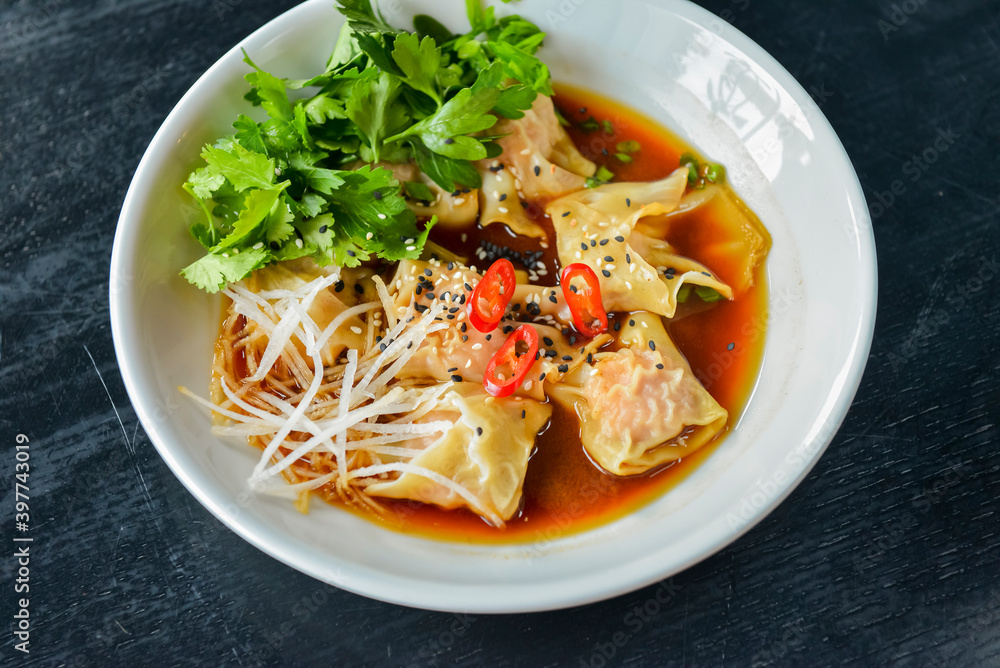 Boiled meat dumplings with fresh parsley, soy sauce and sesame seeds. Delicious meal for dinner. Boiled meat dumplings with fresh parsley, soy sauce and sesame seeds. Delicious meal for dinner.
