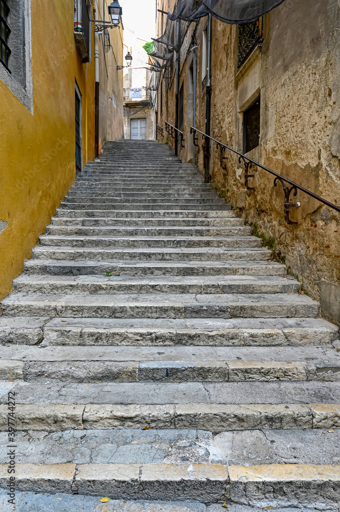 narrow stone stairs with railing between stone walls