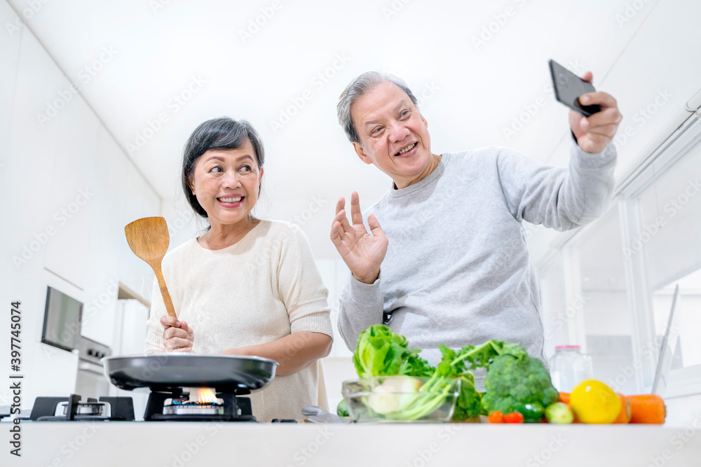 Senior couple doing video call while cook at home