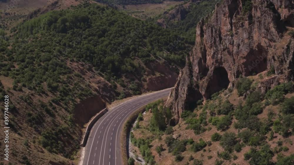 Empty wide autobahn. Turkish winding highway through rocky mountains at summer sunny day. Aerial drone view.
