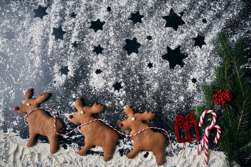 Santa reindeers made of gingerbread cookie on a winter background