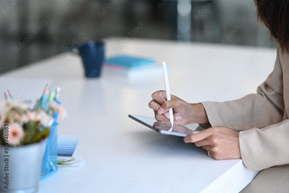 Obraz premium Cropped shot of creative designer female using tablet with stylus pen working on a project in office.