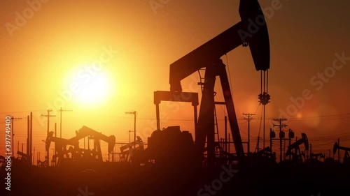 The sun rises behind oil pumps in California