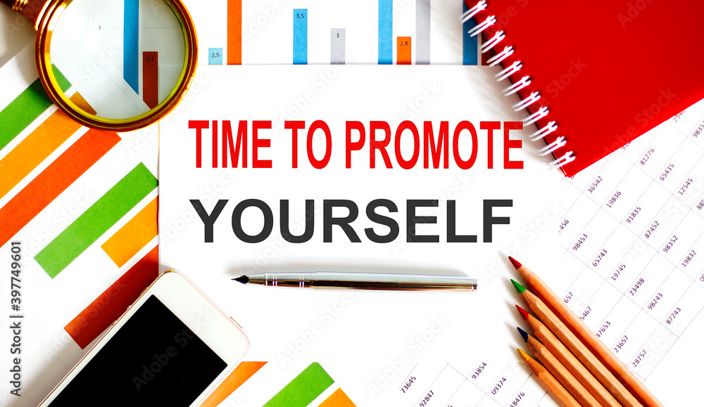 Text Time to Promote Yourself on the notepad with office tools, pen on financial report
